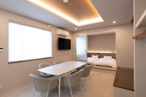 a conference room with a table and chairs and a bed at Precious Hotel 綾川 in Ayagawa