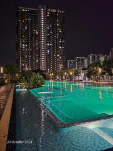 a large swimming pool with green water at night at Sensory Southville Bangi Lux Condo in Kajang