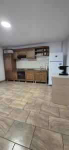 una cucina con armadi in legno e pavimento piastrellato di Pensiunea CORIMEN Vadu Crisului a Vadu Crişului