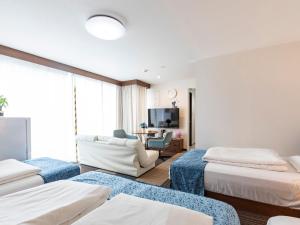a hotel room with three beds and a living room at Tabist Sakuragawa River Side Hotel in Osaka +6 photos