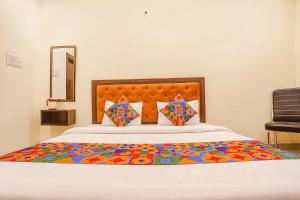 a bedroom with a large bed with a colorful comforter at Hotel Standard Inn - Nr Prayagraj Railway Station in Prayagraj