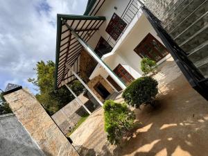a house with a staircase leading up to a building at Lilies holiday inn in Kandy