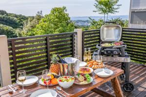 a table with food and a grill on a deck at Hope Hills-Hiramatsutei- in Nanki Shirahama