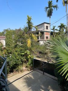 a house on top of a hill with palm trees at Mini Sweet Haven in Digboi