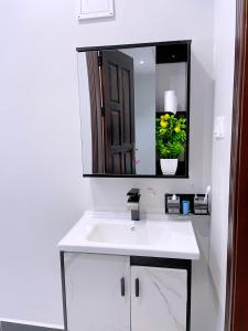 a bathroom with a white sink and a mirror at Sn Suites apartment in Kampala +20 photos