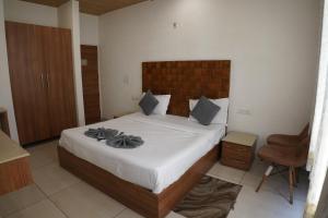 Un dormitorio con una cama grande y una silla. en Hotel Sharrytel, en Zirakpur