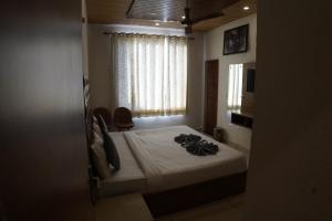 un dormitorio con una cama y una ventana en Hotel Sharrytel, en Zirakpur