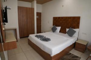 Un dormitorio con una cama grande con cabecero de madera. en Hotel Sharrytel, en Zirakpur