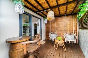 a porch with a wooden deck with a table and chairs at L'HORIZON F2 ti cocooon in Petite Île