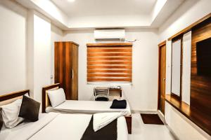 a small room with a bed and a window at Dream Suites Hotel in Hyderabad