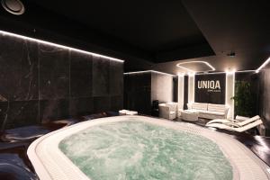 a large jacuzzi tub in a room with chairs at Suncity Hotel & SPA in Šiauliai