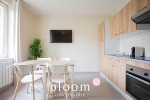 une cuisine avec une table et des chaises dans une pièce dans l'établissement Le cocon de Solignac appartement neuf, à Nancy