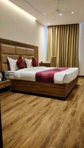a bedroom with a large bed in a room at hotel pearl wood in Zirakpur +7 photos