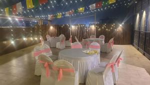 a room with white tables and chairs and flags at hotel pearl wood in Zirakpur
