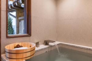 a bathroom with a tub with a sink and a mirror at Luxury Hanok Stay Blue Dot in Seoul