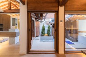 an open door to a courtyard with potted plants at Luxury Hanok Stay Blue Dot in Seoul