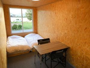 酒田市にあるＳＡＫＡＴＡＮＴＯ Ｃｏｎｔａｉｎｅｒ Ｈｏｔｅｌ ＣＡＭＰＳ - Vacation STAY 93793vのベッド、テーブル、窓が備わる客室です。