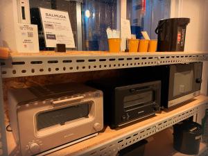 a microwave and a toaster oven on a shelf at ＳＡＫＡＴＡＮＴＯ Ｃｏｎｔａｉｎｅｒ Ｈｏｔｅｌ ＣＡＭＰＳ - Vacation STAY 93807v in Sakata