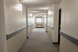 a corridor of a hospital hallway with a table in the distance at Super 8 by Wyndham Whitecourt in Whitecourt