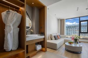 ein Badezimmer mit einem Waschbecken und ein Wohnzimmer in der Unterkunft Shangri La Anyu Garden Resort Hotel in Shangri-La + 50 Fotos