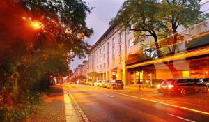 a city street at night with cars parked on the street at Best Western Macrander Hotel Dresden in Dresden