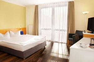a hotel room with a bed and a large window at Best Western Macrander Hotel Dresden in Dresden