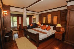 a bedroom with a bed and a chair and a couch at Suan Bua Hotel & Resort in Ban Pong