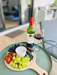 a plate of fruit and a bottle of wine on a table at Bushbuck Rest in Marloth Park