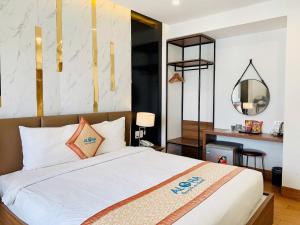 a bedroom with a large bed and a mirror at Aloha Hotel in Quy Nhon