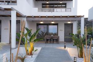 a home with a patio with a table and chairs at Waves Skyros in Skiros