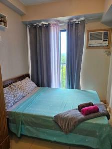 a bedroom with a bed and a window with curtains at Cloud Studio at Northpoint in Davao City +7 photos