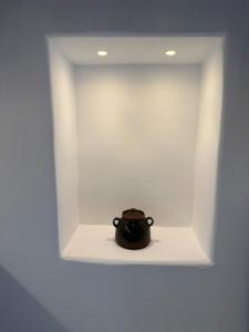 a small black pot sitting in a white box at Aliprantis residence in Naousa
