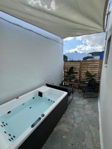 a large bath tub in a room with a balcony at Aliprantis residence in Naousa