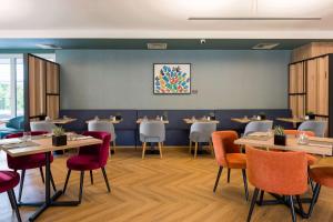 a dining room with tables and chairs at Hilton Garden Inn Milan Malpensa in Somma Lombardo