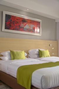 a bedroom with two beds and a painting on the wall at iCheck inn Thapra in Bangkok +29 photos