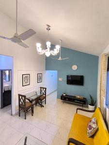 a living room with a table and a tv at Su Casa Candolim 1Bhk Beachside Apartment in Candolim