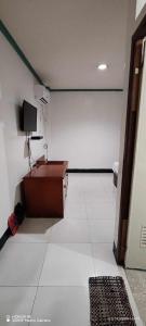 a room with a table and a tv on a wall at Asia Novo Boutique Hotel - Cabuyao Laguna in Cabuyao +4 photos