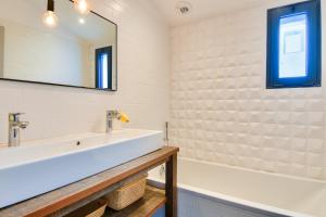 a bathroom with a sink and a mirror and a tub at 6 adultes et 2 enfants - piscine et accès plage direct in La Guérinière +13 photos