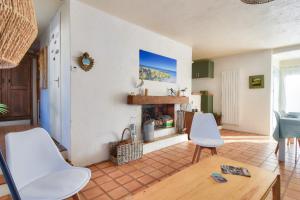 ein Wohnzimmer mit 2 weißen Stühlen und einem Kamin in der Unterkunft À 300m de la plage, maison pour 6 personnes in La Guérinière + 8 Fotos