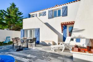 eine Terrasse mit Stühlen und einem Tisch vor einem Haus in der Unterkunft À 300m de la plage, maison pour 6 personnes in La Guérinière