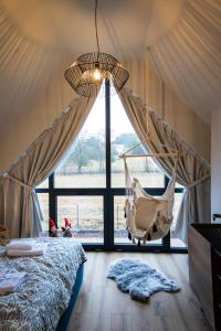 a bedroom with a hammock swing in a tent at Stodoły Pod Gajem z Balią i Sauną in Trzebniów