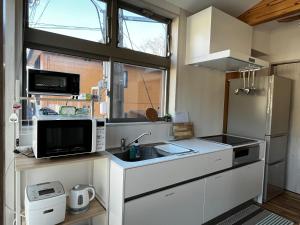 a small kitchen with a sink and a microwave at Toraya Attic in Shimoda +49 photos