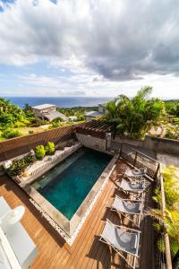 an overhead view of a swimming pool on a deck with chairs at L'HORIZON F2 ti cocooon in Petite Île