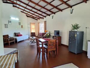 a living room with a table and a refrigerator at Pristine Stay by LexStays in Coonoor +28 photos