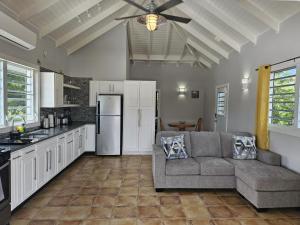 a living room with a couch and a kitchen at 216A Upper Level, Deluxe 1 Bedroom in Jolly Harbour