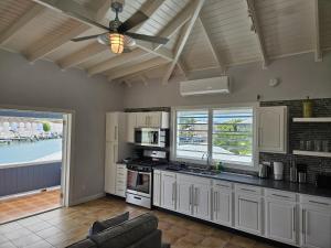 a kitchen with white cabinets and a ceiling fan at 216A Upper Level, Deluxe 1 Bedroom in Jolly Harbour