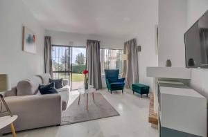 Una sala de estar con un sofá y sillas y un televisor. en Calahonda Park, en Cabopino
