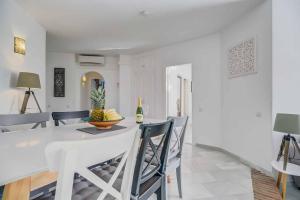 Un comedor blanco con una mesa y sillas blancas. en Calahonda Park, en Cabopino