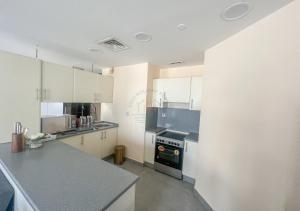Una cocina con gabinetes blancos y un horno de estufa. en Snug Studio With City Views, Perfect For Couples, en Dubái