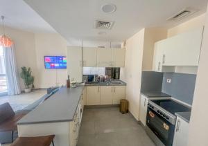 Una cocina con gabinetes blancos y encimeras negras. en Snug Studio With City Views, Perfect For Couples, en Dubái
